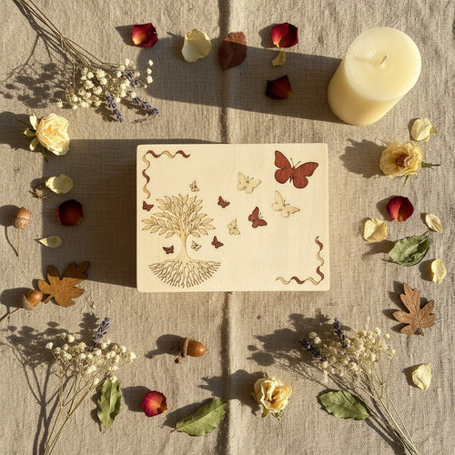 Holzschachtel mit Dekor Lebensbaum & Schmetterlinge aus Sperrholz, lasergraviert, Draufsicht auf Leinenstoff mit Trockenblumen, Rosenblüten und Kerze