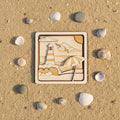 3D Multilayer-Bild Leuchtturm mit Sonnenschirm aus Sperrholz, lasergraviert, Draufsicht im Sand mit Muscheln